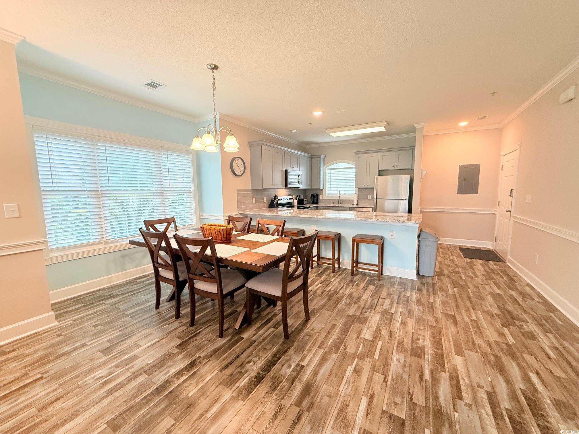4860 Carnation Circle, Unit 17105 Myrtle Beach, SC 29577 - Photo 9 of 29 Dining space featuring light wood-type flooring, a chandelier, ornamental molding, electric panel, and recessed lighting