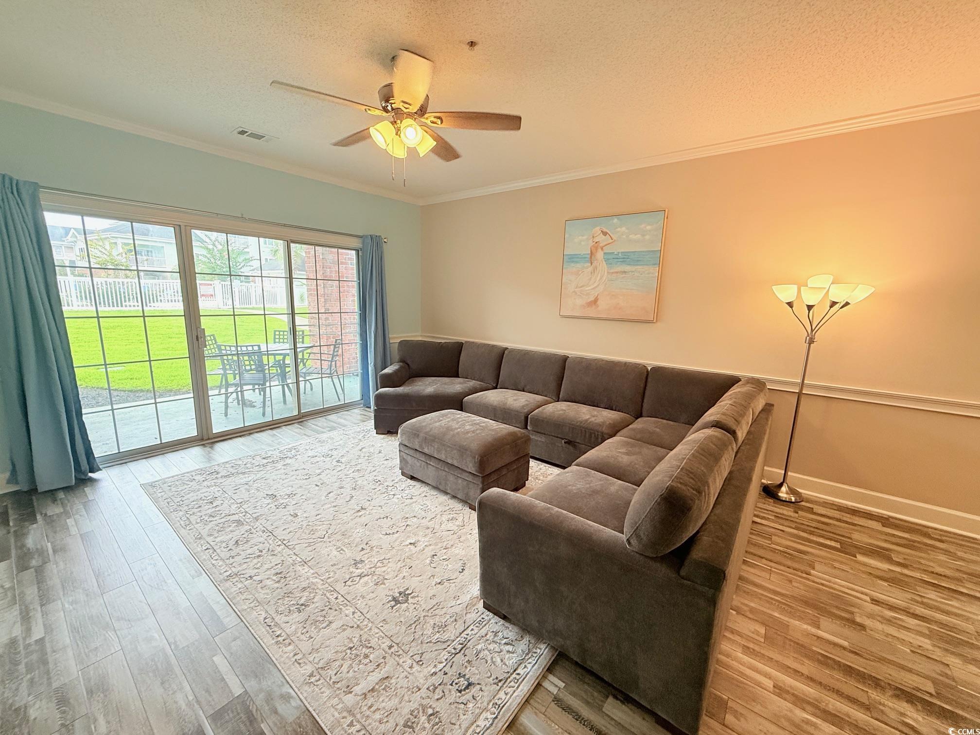 4860 Carnation Circle, Unit 17105 Myrtle Beach, SC 29577 - Photo 10 of 29 Living room featuring crown molding, a textured ceiling, light wood-style flooring, and a ceiling fan