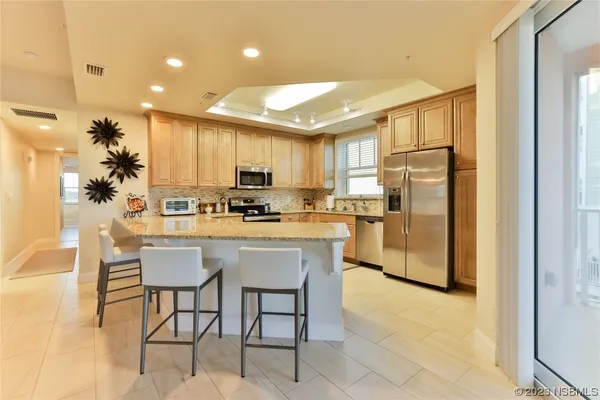 a kitchen with a refrigerator a stove cabinets and dining table