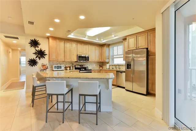 a kitchen with a refrigerator a stove cabinets and dining table