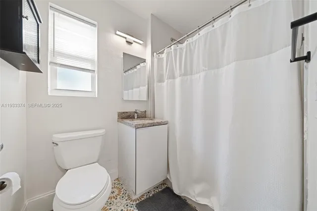 a white toilet sitting next to a bathroom sink