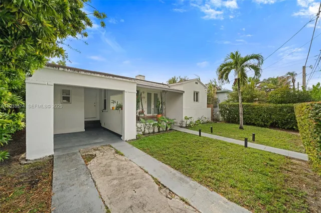 a view of a house with backyard and a tree