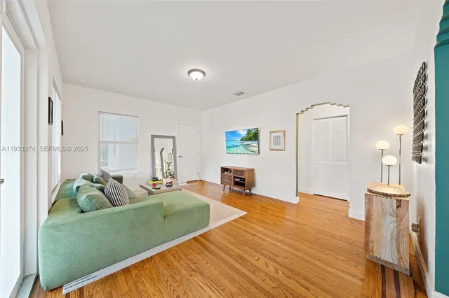 a living room with furniture and a wooden floor