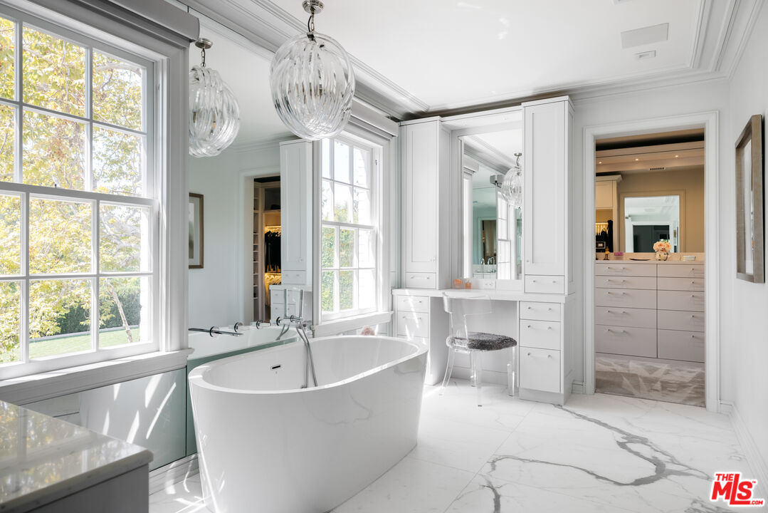 301 Copa De Oro Road Los Angeles, CA 90077 - Photo 20 of 33 a spacious bathroom with a bathtub and chandelier