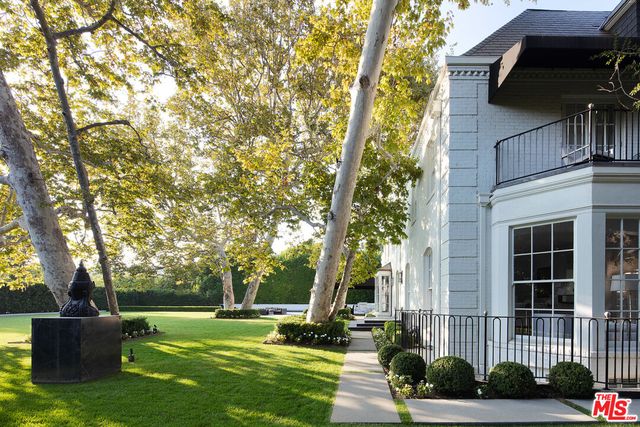 a view of a patio with table and chairs potted plants and large tree