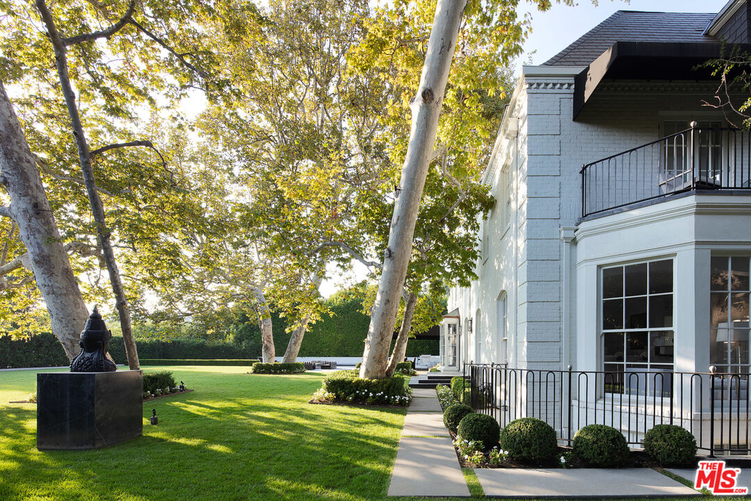 301 Copa De Oro Road Los Angeles, CA 90077 - Photo 27 of 33 a view of a patio with table and chairs potted plants and large tree