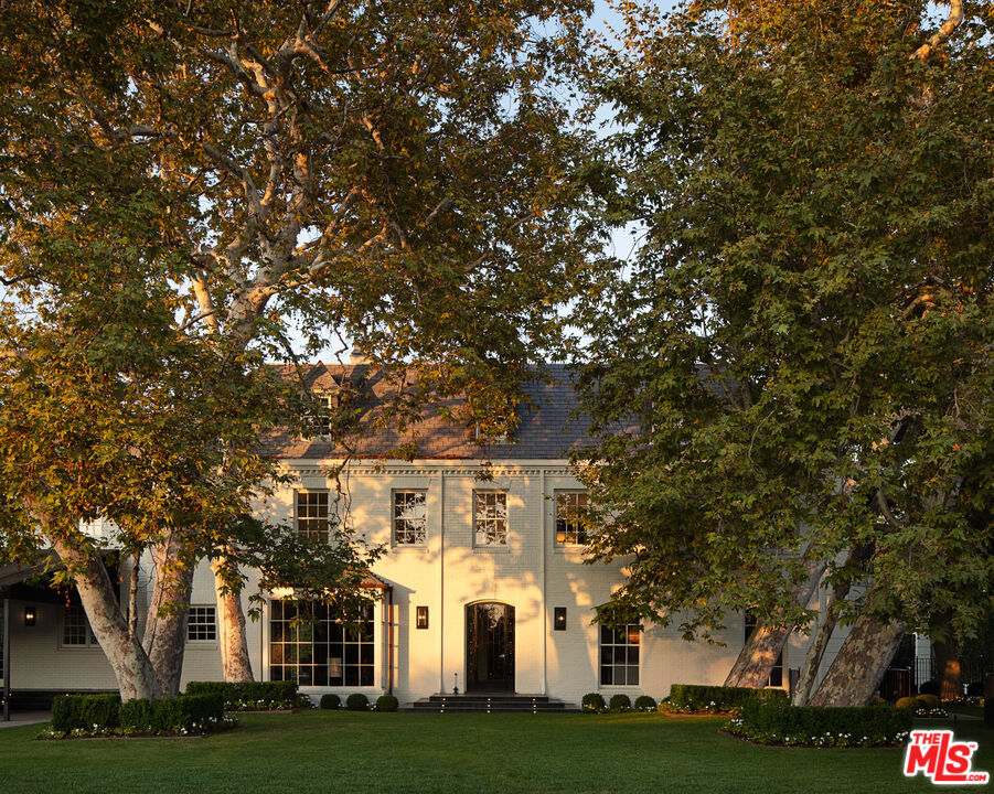 301 Copa De Oro Road Los Angeles, CA 90077 - Photo 29 of 33 a view of a white house with a big yard and large trees