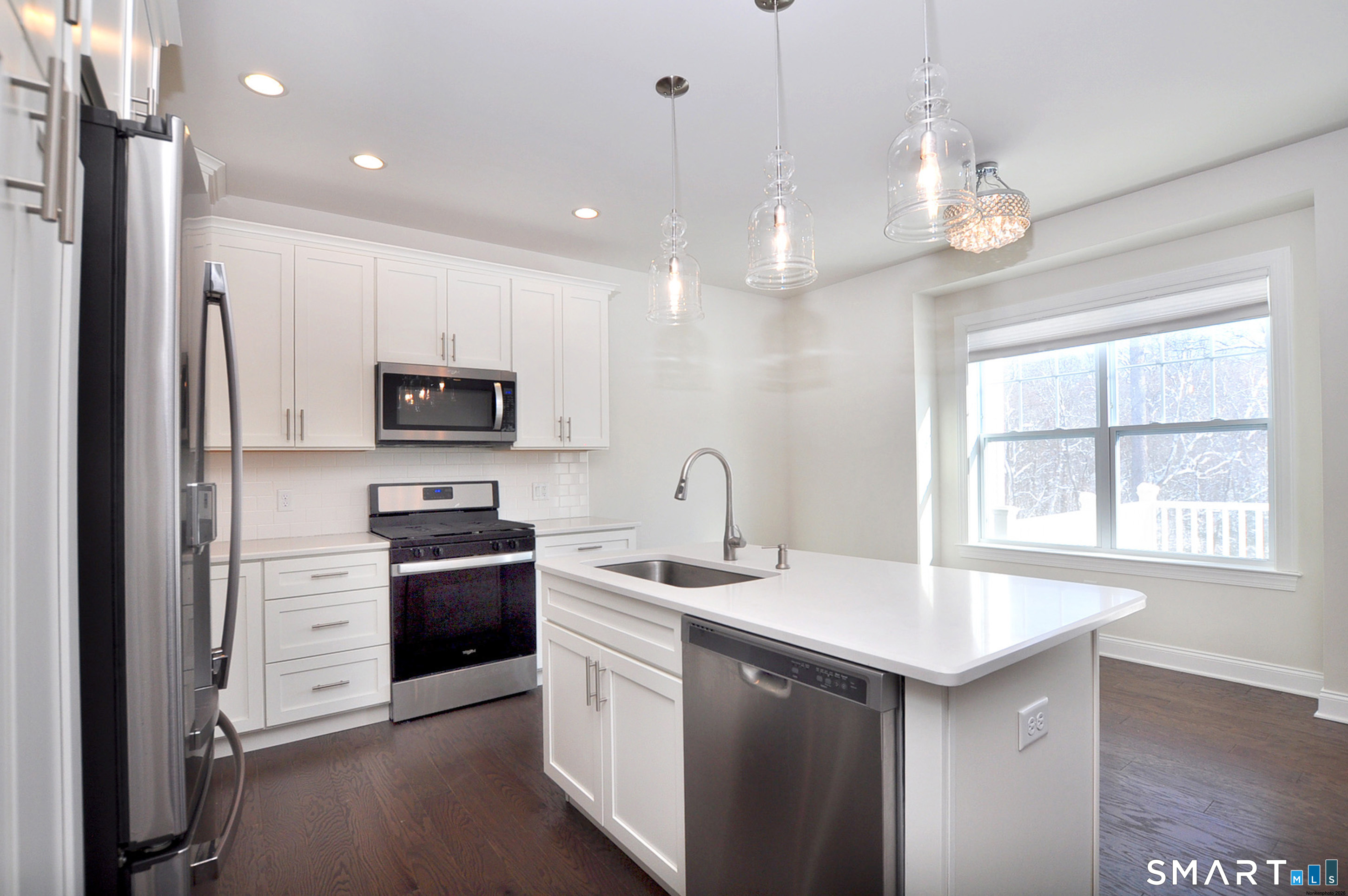 149 Ridgewood Drive Middlebury, CT 06762 - Photo 11 of 30 a kitchen with a sink stainless steel appliances a large window and cabinets
