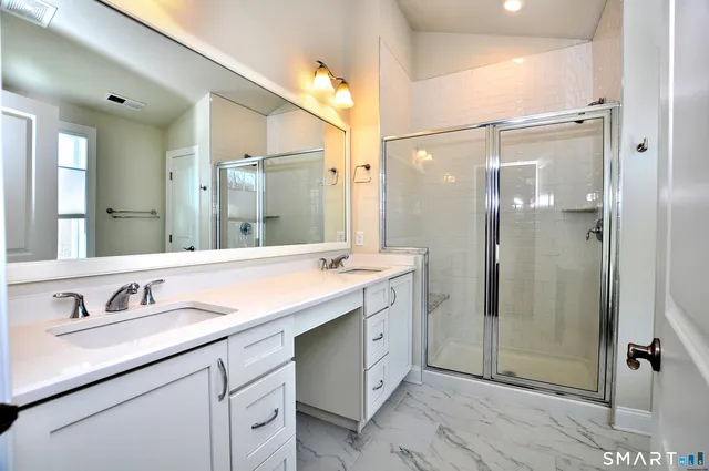a bathroom with a shower sink double and mirror