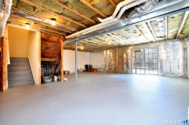 a view of an empty room with wooden floor and windows