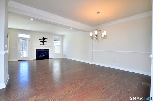a view of a livingroom with a fireplace wooden floor and a window