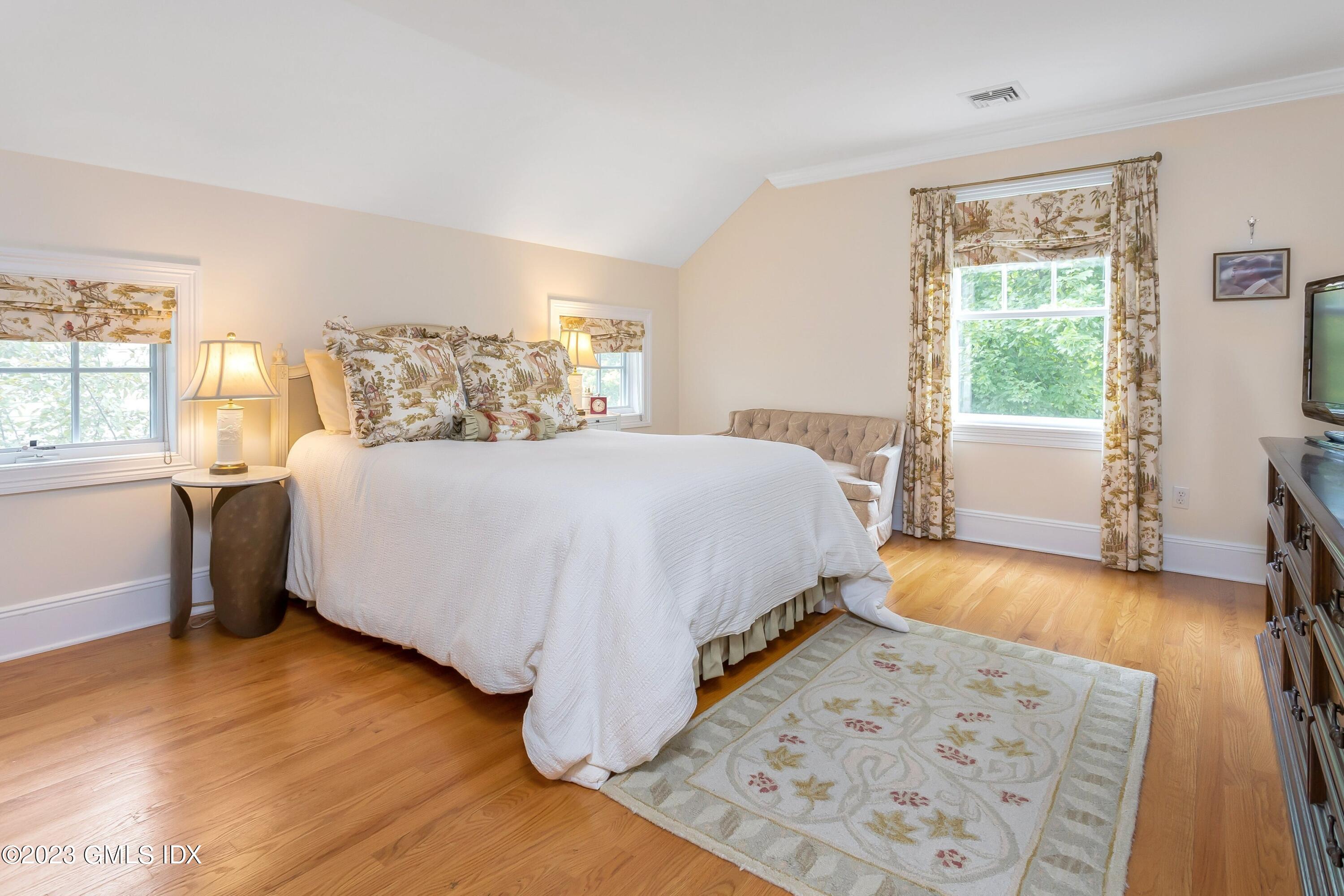 124 East Elm Street, Unit WEST Greenwich, CT 06830 - Photo 12 of 23 a bedroom with a bed and a large window with wooden floor