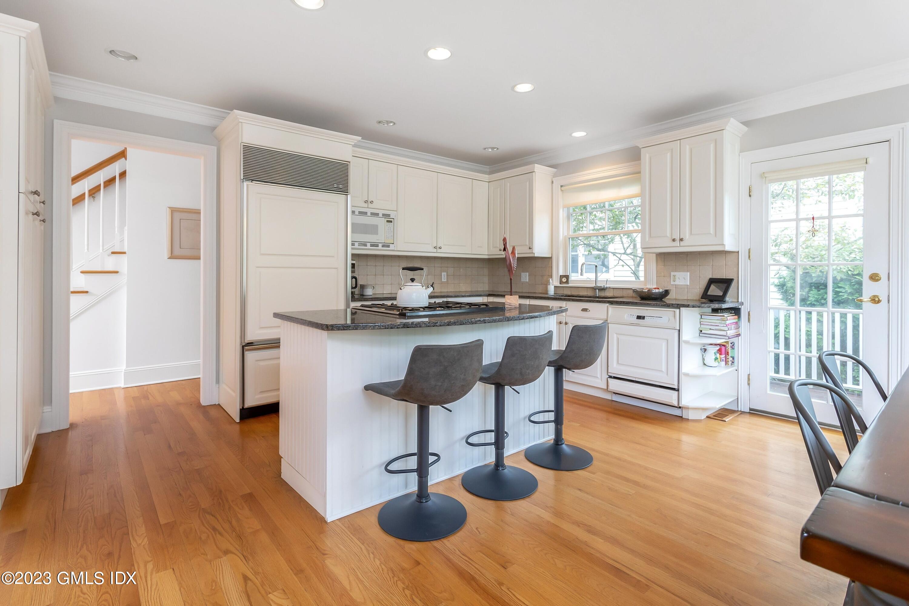 124 East Elm Street, Unit WEST Greenwich, CT 06830 - Photo 6 of 23 a kitchen with stainless steel appliances granite countertop a stove top oven a sink a dining table and chairs