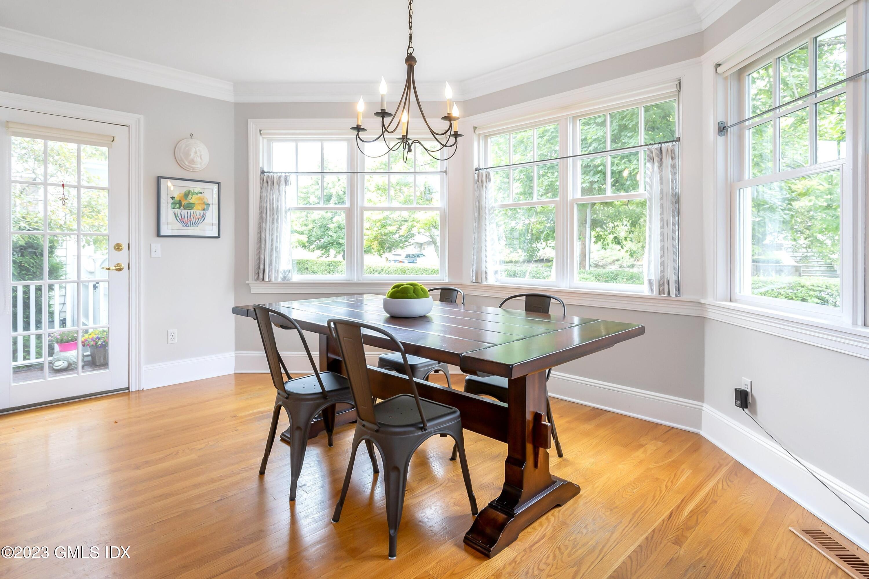 124 East Elm Street, Unit WEST Greenwich, CT 06830 - Photo 8 of 23 a view of a dining room with furniture wooden floor and a chandelier