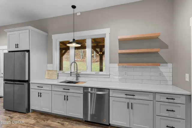 a kitchen with appliances cabinets and a potted plant