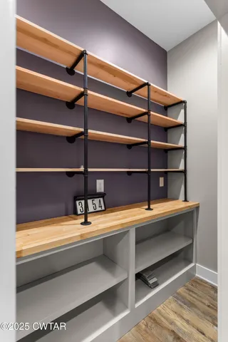 a view of a room with shelves and wooden floor