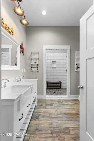 a spacious bathroom with a sink a mirror and a shower