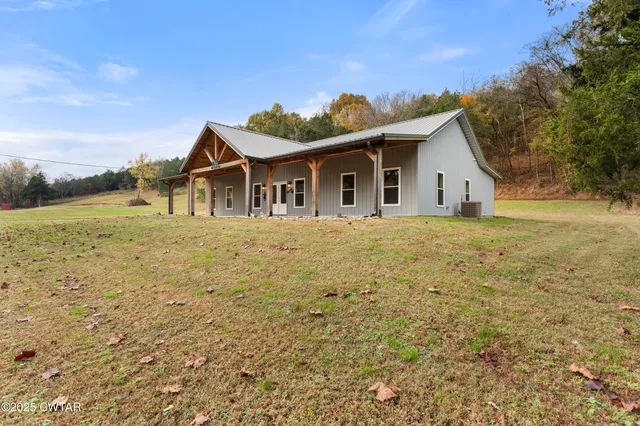 a white house with a big yard and large trees