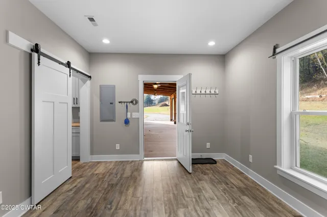 a view of empty room with wooden floor and window