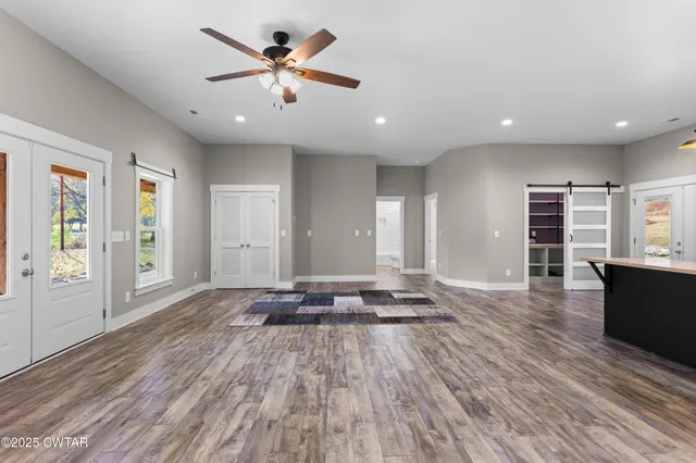 a view of a big room with wooden floor and windows