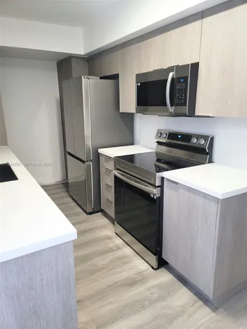 a kitchen with stainless steel appliances a stove microwave and refrigerator