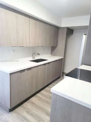 a kitchen with a sink and white cabinets
