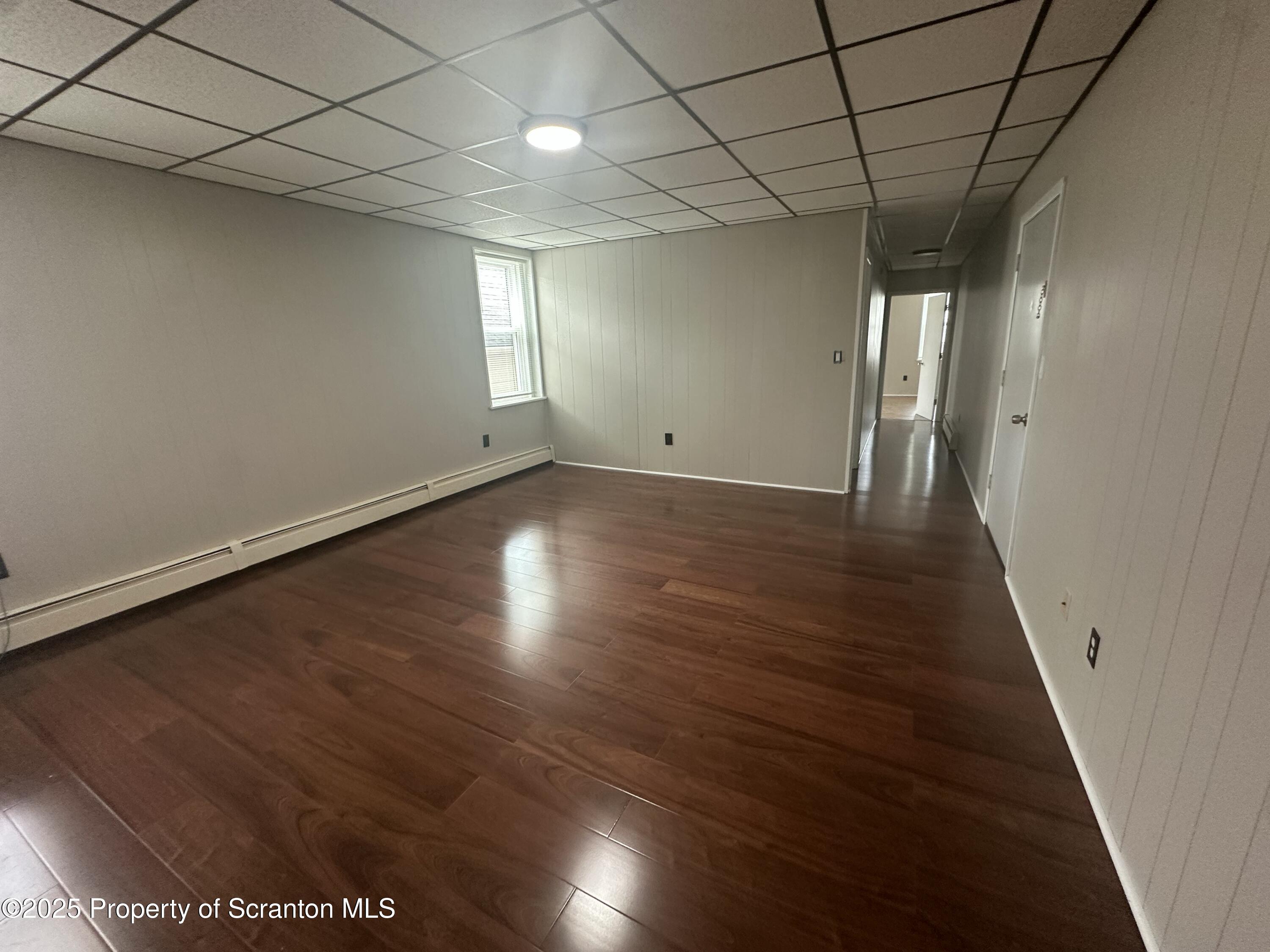 65 Center Street, Unit 2 Pittston, PA 18640 - Photo 3 of 14 an empty room with wooden floor and windows