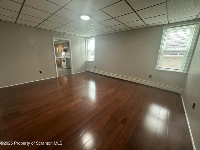 a large kitchen with a sink and wooden floor