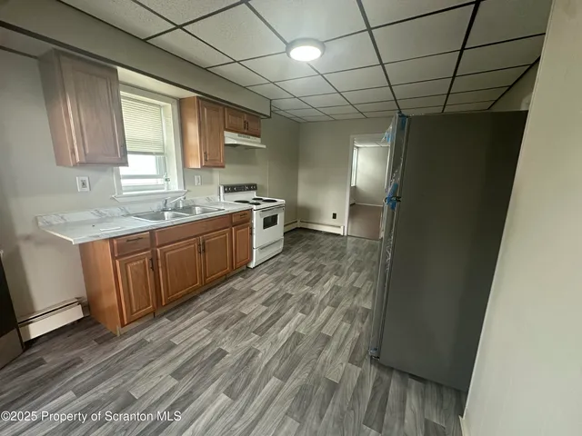 a kitchen with a stove wooden floor and a window
