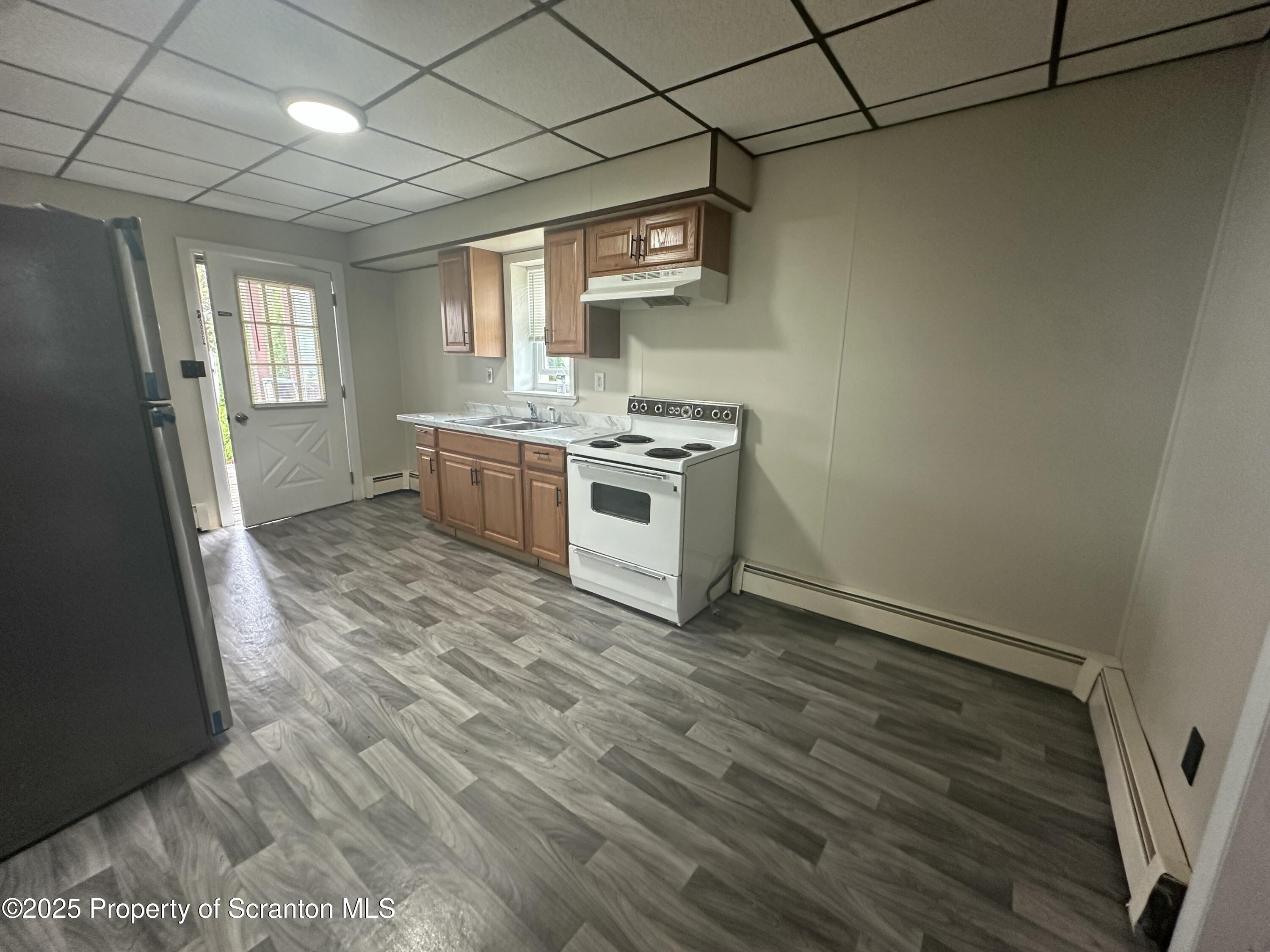 65 Center Street, Unit 2 Pittston, PA 18640 - Photo 6 of 14 a kitchen with a stove wooden floor and a window