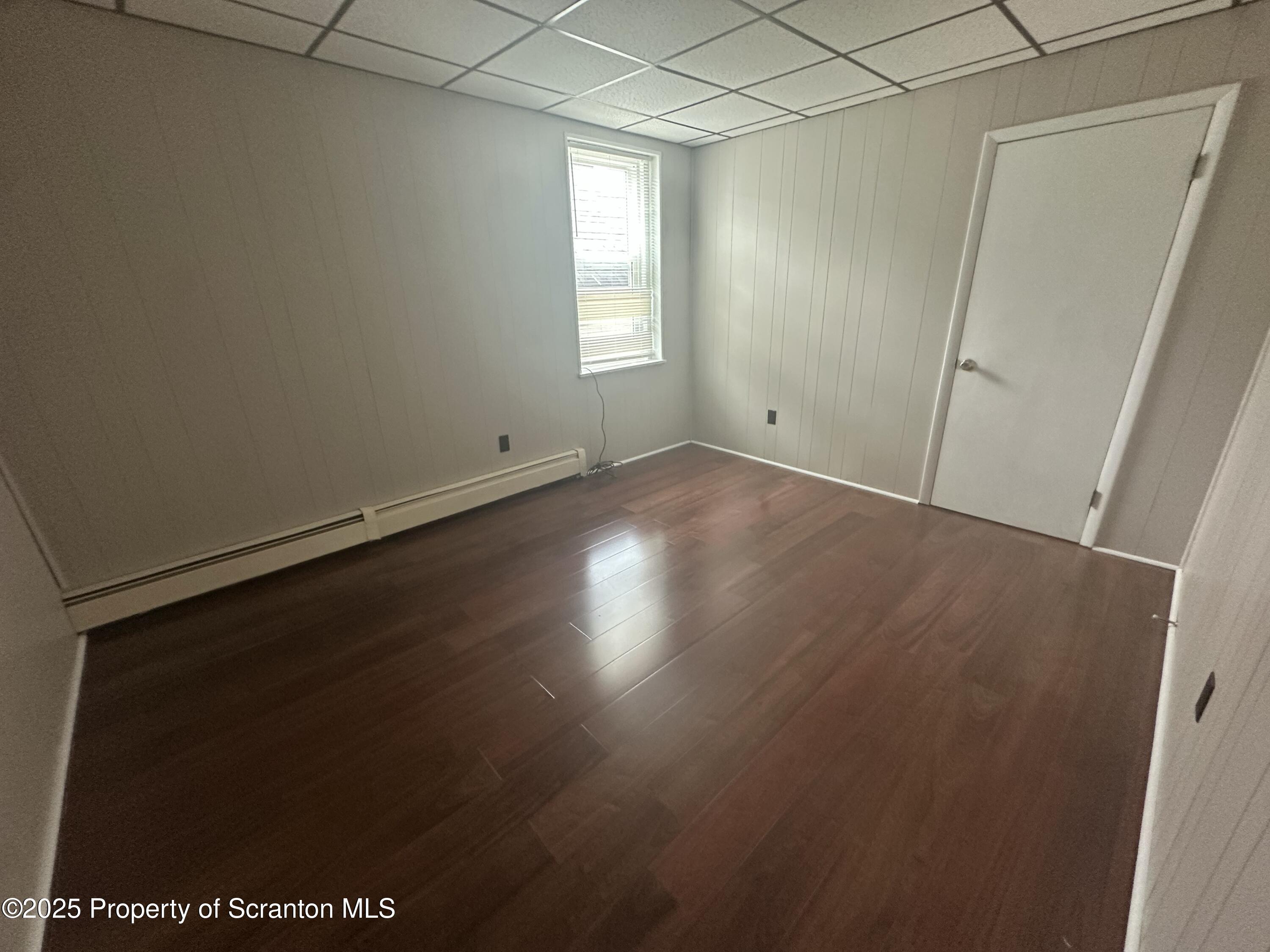 65 Center Street, Unit 2 Pittston, PA 18640 - Photo 8 of 14 an empty room with wooden floor and windows