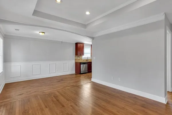 a view of an empty room with closet and wooden floor