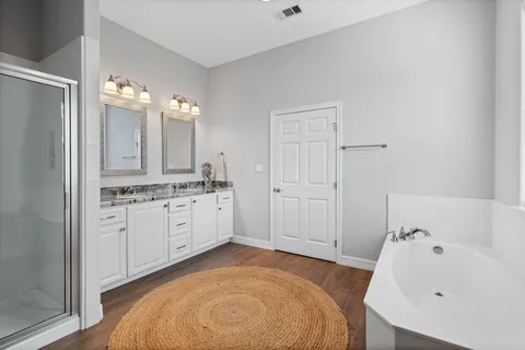 a spacious bathroom with a tub sink and mirror