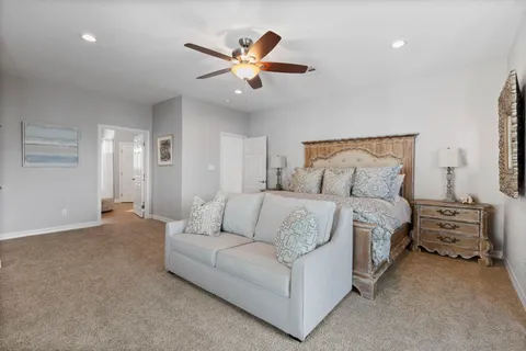 a spacious bedroom with a bed and ceiling fan