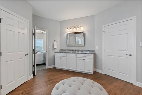 a spacious bathroom with a granite countertop sink and a mirror