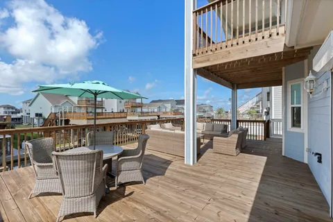 a view of a patio with dining table and chairs with wooden floor