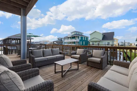 a roof deck with couches and potted plants