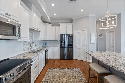 a kitchen with stainless steel appliances granite countertop a refrigerator stove microwave and sink