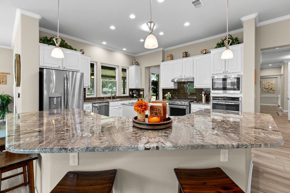 103 Trail Rider Way Georgetown, TX 78633 - Photo 21 of 39 a kitchen with stainless steel appliances granite countertop a refrigerator and a sink