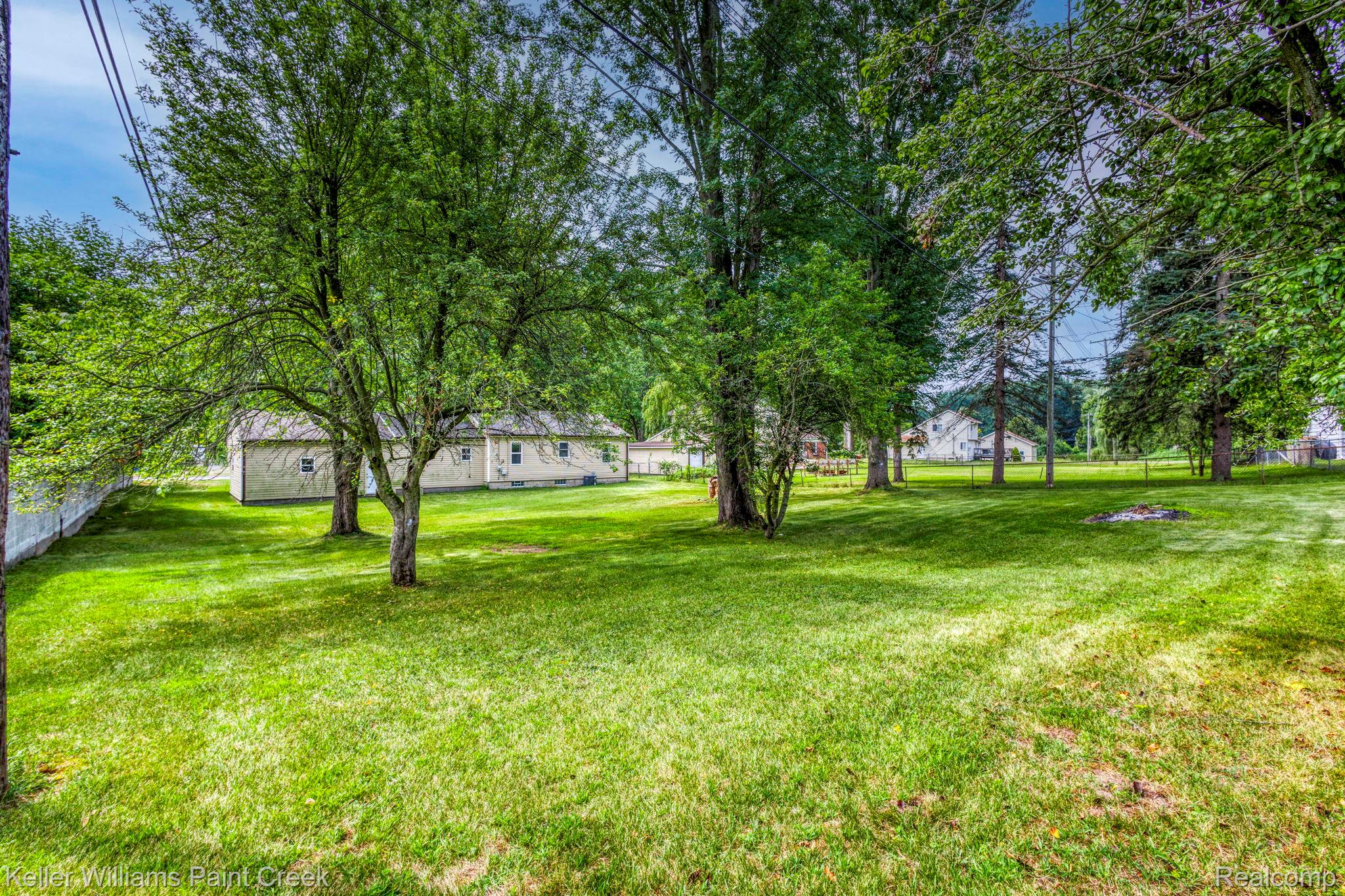 2244 Hammerslea Road Lake Orion, MI 48359 - Photo 18 of 21 Expansive green lawn with mature trees and a partial white fence
