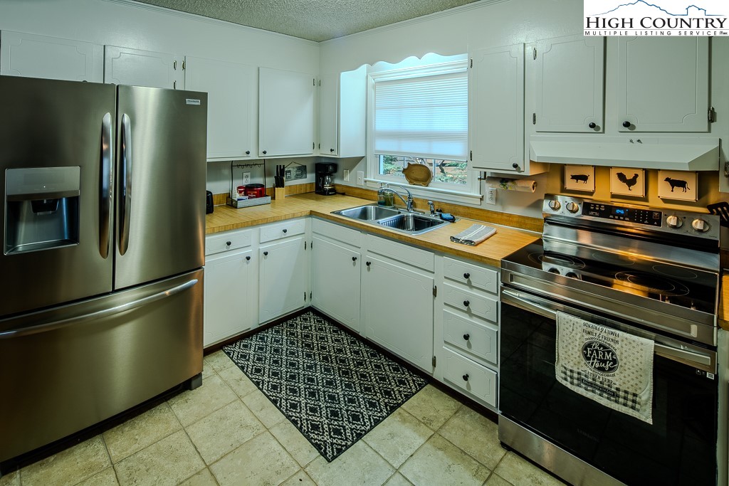 198 Black Pine Road Newland, NC 28657 - Photo 13 of 34 a kitchen with stainless steel appliances a refrigerator sink and cabinets