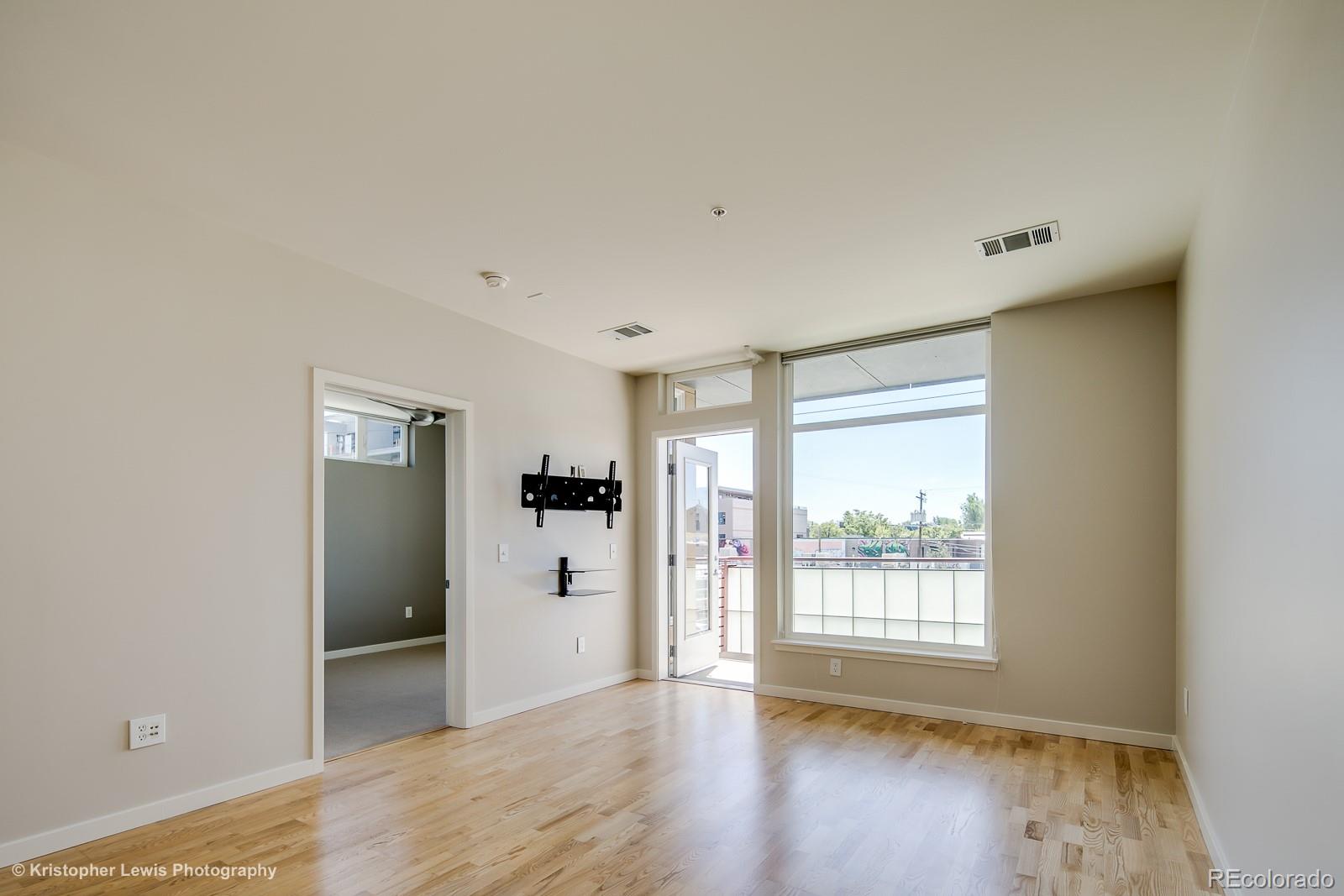 3101 Blake Street, Unit 308 Denver, CO 80205 - Photo 7 of 19 a view of an empty room with wooden floor and a window