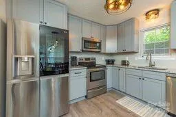 a kitchen with stainless steel appliances granite countertop a stove a sink and a refrigerator