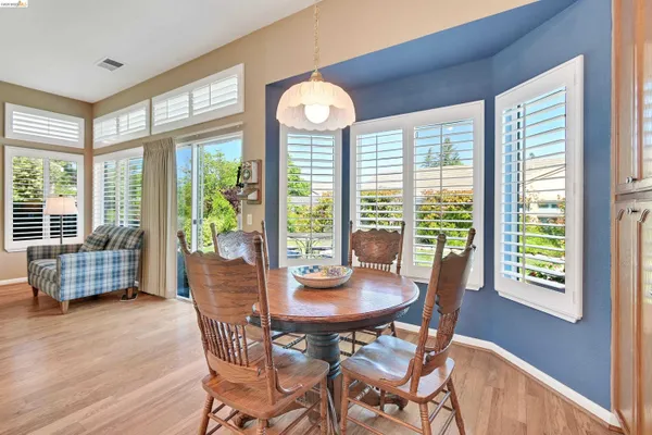 a dining room with furniture large windows and wooden floor