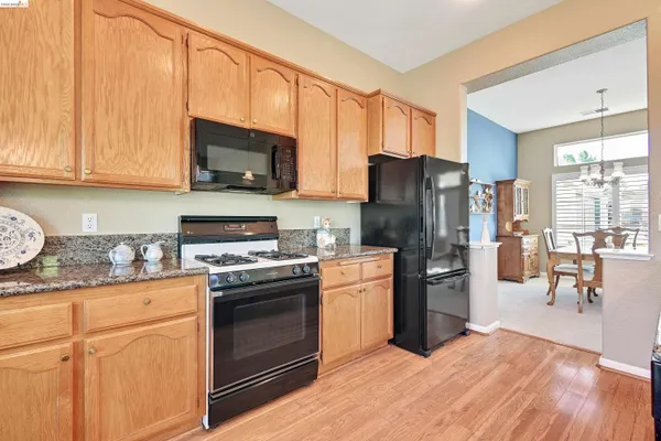 a kitchen with stainless steel appliances granite countertop a refrigerator stove top oven and sink