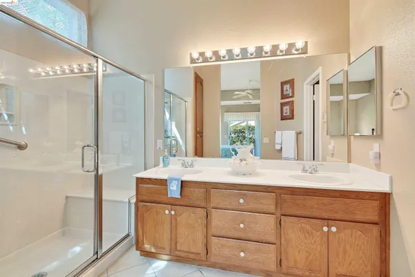 a bathroom with a double vanity sink mirror and shower