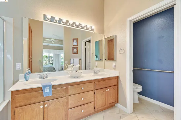 a bathroom with a double vanity sink toilet and shower
