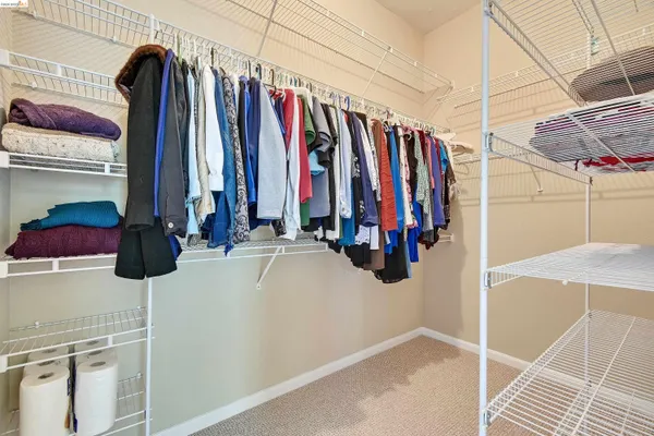 a view of walk in closet with clothes and shoes