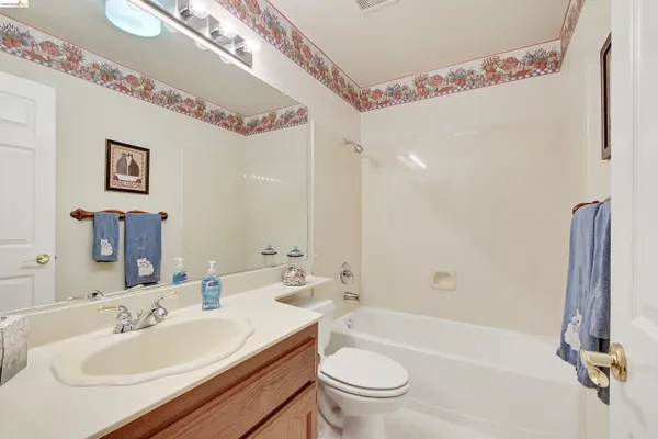 a bathroom with a sink a toilet a mirror and shower
