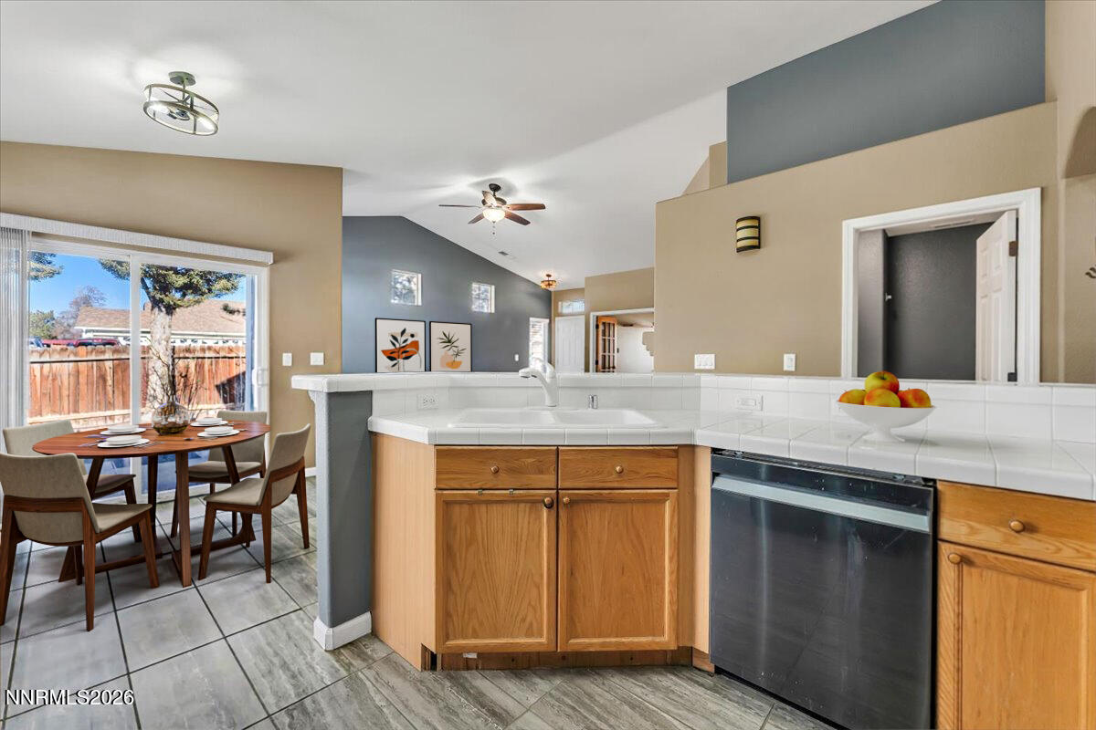 7663 La Ramba Drive Sparks, NV 89436 - Photo 11 of 27 a kitchen with stainless steel appliances granite countertop a sink and a wooden cabinets